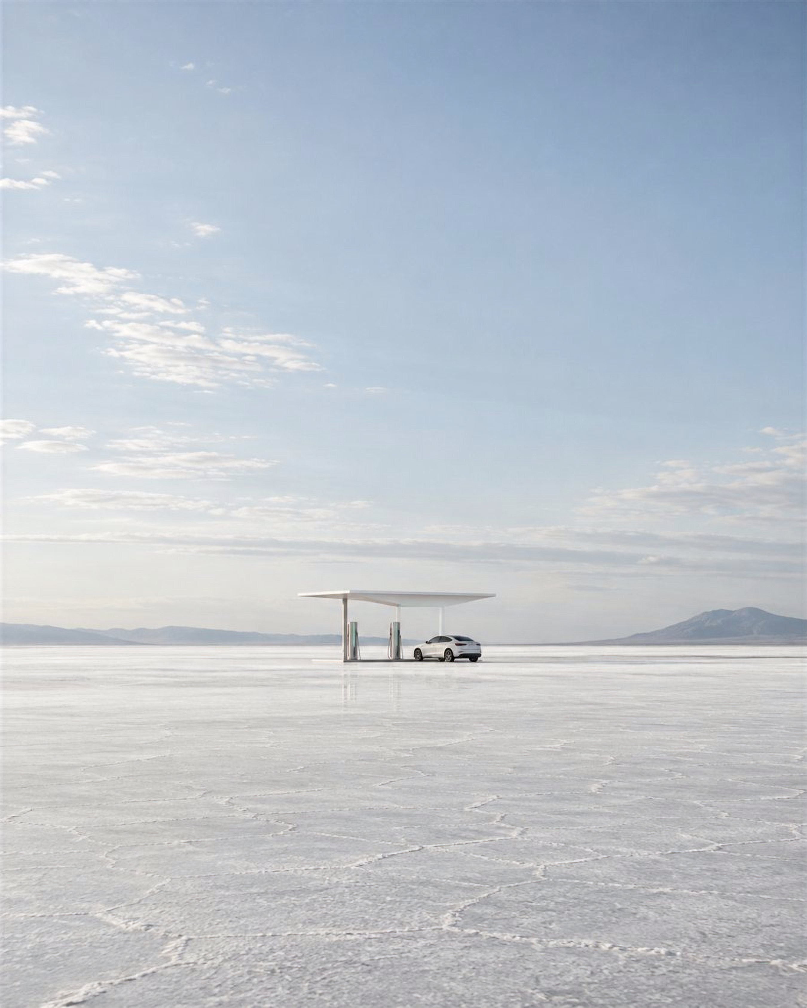 A white charging canopy alone on a wide salt flat under a pale sky